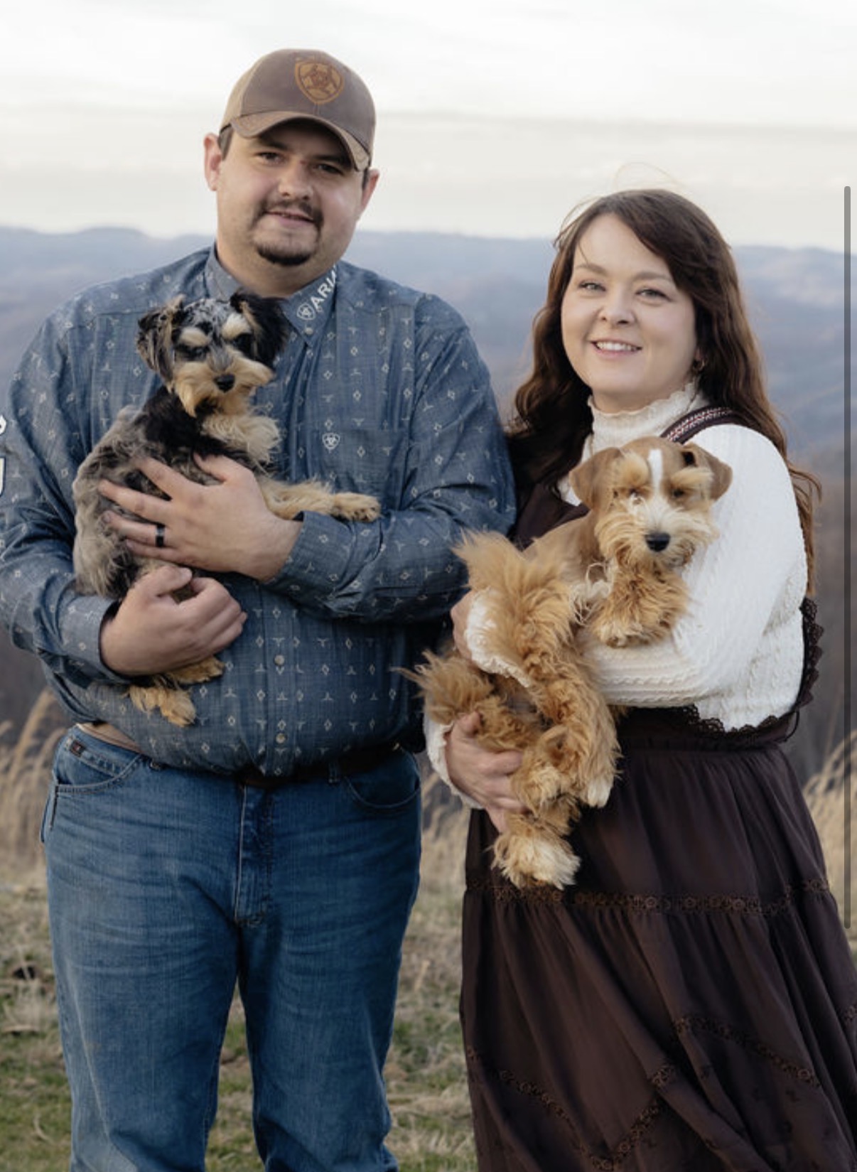 Dixie and her husband holding two Mini Schnauzer puppies